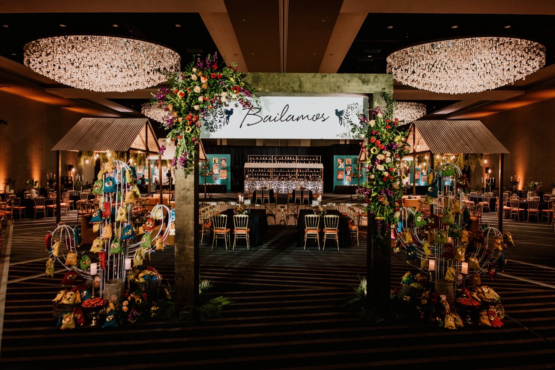 Bailamos-themed sangeet entrance archway with lush florals and teal and gold decor